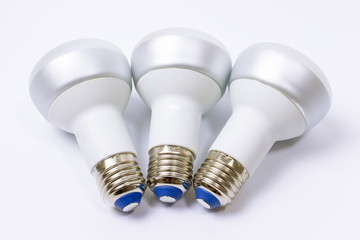 Three energy saving lamp with e27 socket on white background