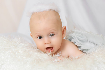 portrait of a sweet little 5 months old baby boy with an open mouth, looking up. copyspace for your text