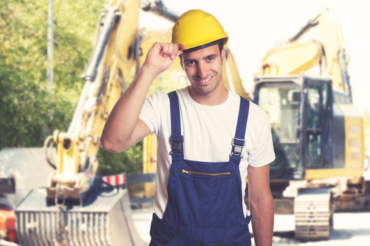 Yellow earthmover with handsome latin american construction worker