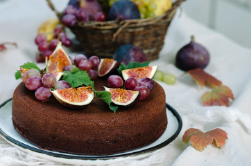 Autumn chocolate cake decorated with figs and grapes