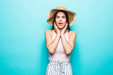 Portrait of shocked excited young woman standing isolated over blue background.