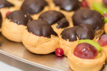 eclairs with chocolate. on a dish for party. Horizontal. background out of focus.