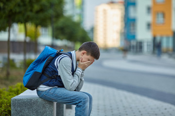 Obraz premium Schoolboy crying in the yard of the school