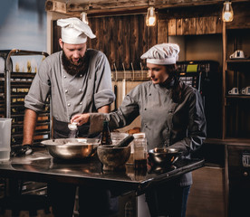 Cook assistant pours sesame into a bowl.