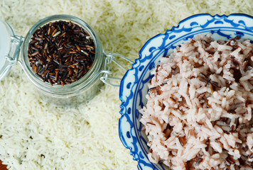 Obraz na płótnie Canvas Cooked Riceberry mixed with white rice and uncooked Rice background.