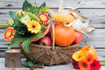 Weidenkorb mit roten Äpfeln und Kürbisse rustikal vor Holz als Dekoration für den Herbst