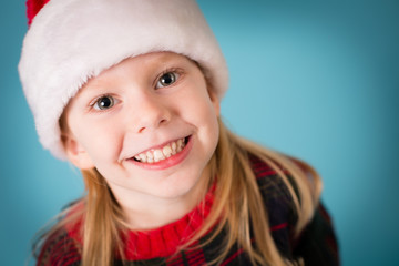 Happy Little Christmas Girl in Santa Hat, Isolated on Teal