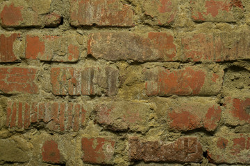 old wall of red brick with crumbled plaster as background