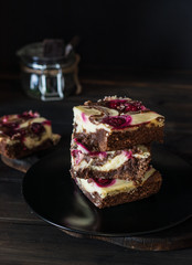 Chocolate cheesecake layered with brownie and dark cherrie. Chocolate cherrie cake. Pieces of chocolate cake. Winter dessert. Traditional american cuisine. Still life of food. Dark food photo.