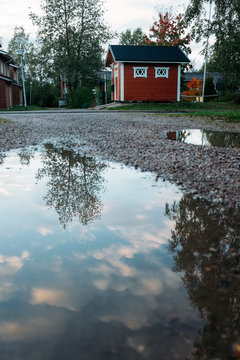 reflection in a puddle after a rain of a classic Scandinavian red house