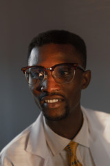 Handsome guy doctor in white lab coat with stethoscope on white background