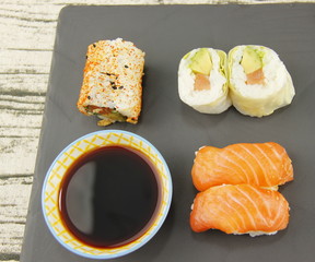 Sushi, maki et sauce soja sur une ardoise