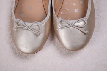 Kids shoes of gold colour.Moccasins for little princess