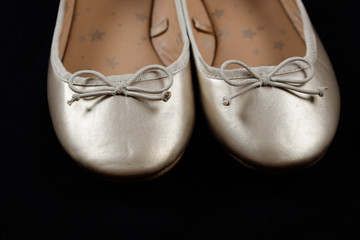 Kids shoes of gold colour.Moccasins for little princess