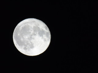 An amazing caption of the full moonlight over the city by night in summer days with some clouds and foggy