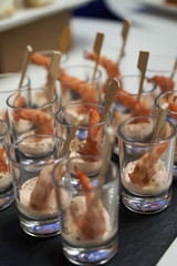 Shrimp cocktail with sauce on black stone tray table. Glasses with seafood snacks, close-up. Smorgasbord  food concept 