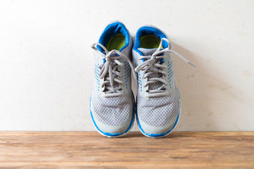 Walking sneakers shoes put on old wooden table desk.