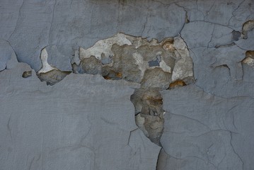 gray texture from an old wall with rubbed paint and cracks