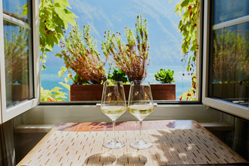 Two glasses of white wine near the window