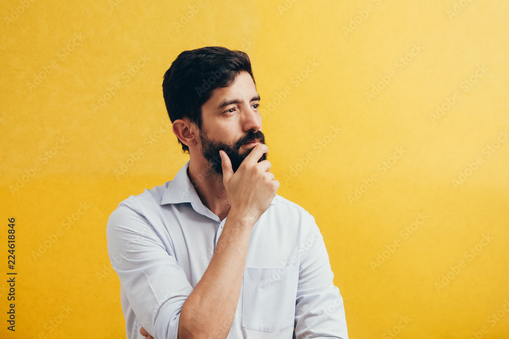 Wall mural pensive bearded man on a yellow background