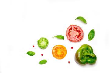 sliced vegetables tomato and pepper and paprika and salad and Basil and pepper peas on white background 