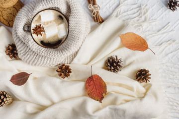 Autumn and Winter composition. Hot coffee with marshmallows, scarf, cookies, bumps and autumn leaves. Flat lay, top view