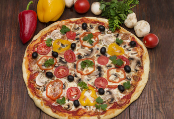 Pizza with ham, pepper and olives. Delicious italian pizzas on a wooden background