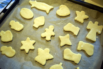 Figures from the dough lie on a baking tray.  Homemade baking. Selective focus