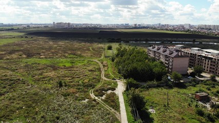 Aerial view of the new district in Krasnodar. View of the fields from the height. Unfinished building.