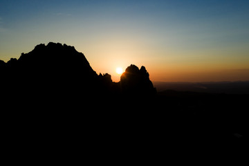 Aerial view of a spectacular sunset behind some rocky mountains in Sardinia, Italy.