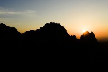 Aerial view of a spectacular sunset behind some rocky mountains in Sardinia, Italy.