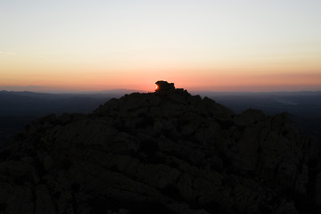 Aerial view of a spectacular sunset behind some rocky mountains in Sardinia, Italy.