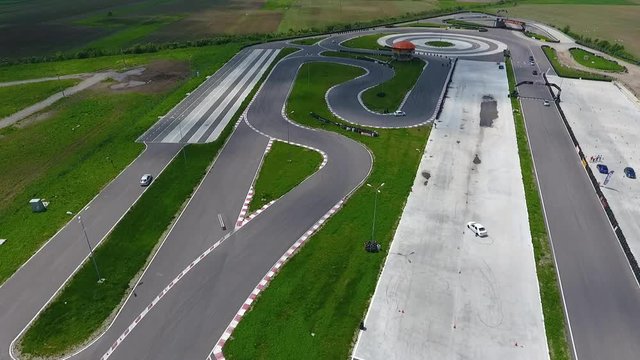 Aerial footage of the Titi Aur racetrack with cars speeding around the curves.