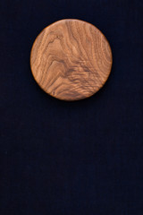 Handmade black walnut round wooden pallet on dark blue hand-dyed burlap	