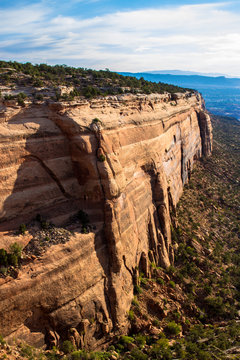 Early-morning light strikes one of the two long, massive rock walls of Red Canyon in Colorado National Monument near the towns of Grand Junction and Fruita