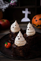 Brownie with ghosts of meringue as the idea of a dessert for Halloween