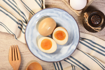Plate of soft boiled eggs on wooden table