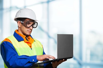 Male worker in hardhat with laptop