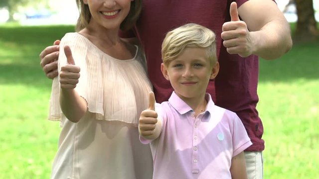 Smiling family show thumbs-up, parents and kid satisfied with insurance program