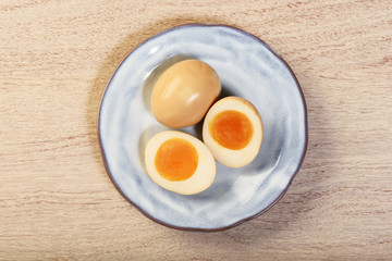 Plate of soft boiled eggs on wooden table