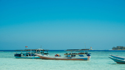 a traditional boat anchored in seashore shallow beach sea in karimun jawa island