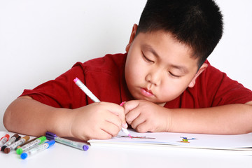 Boy painted on white paper is learning to create a fantasy.