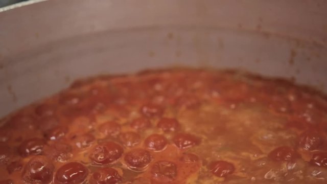 Slow motion at 24 fps from original 60fps. Close up shot of delicious red, bubbling, Italian, tomato sauce for pasta. Slow cooking experience from the best chef in Rome. Buon appetito!