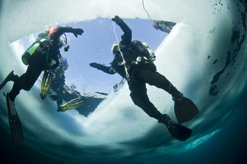Winter ice diving underwater in a quarry in Canada