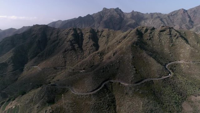 Aerial - Person paragliding over distant mountain