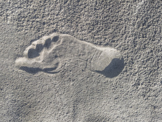 closeup naked footprint impression in rippling sand