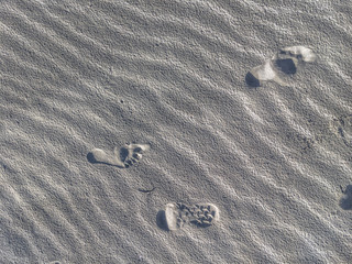 Fototapeta na wymiar footprints and boot impression in rippling sand