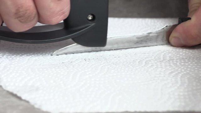 The man is sharpening a kitchen knife