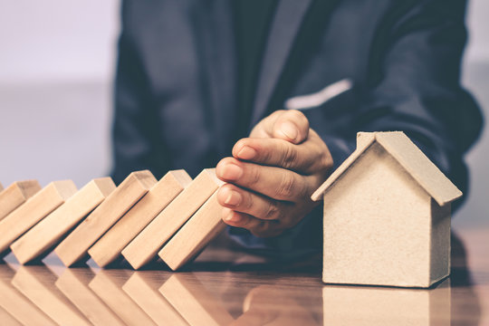 Businessmen use the hands to prevent falling Domino. To maintain the remaining benefits do not fall.