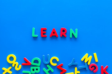 Children learn read concept. Word learn written by plastic letters on blue background top view copy space